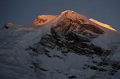
The first rays of sunrise silhouette the Shishapangma main summit (8012m) and the central summit on the right with the steep east face from Kong Tso camp (5198m).
